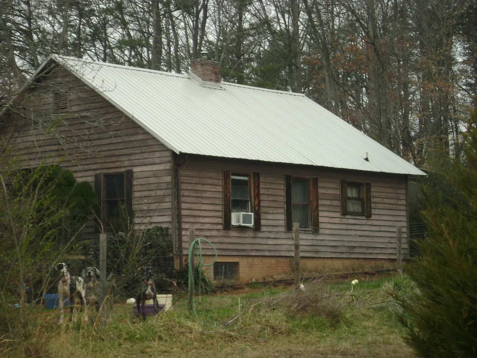 White metal roof on an old wood sided farmhouse, from a Metal Roof Installation job in Woodstock
